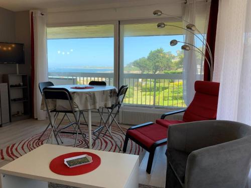 - un salon avec une table, des chaises et une grande fenêtre dans l'établissement Appartement avec WIFI et balcon à Perros-Guirec - FR-1-368-345, à Perros-Guirec