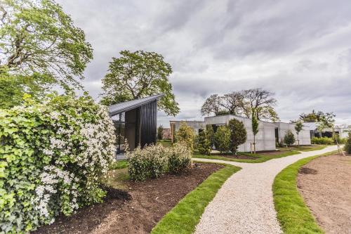 Chathill的住宿－The Garden Rooms，一座带花园和走道的房子