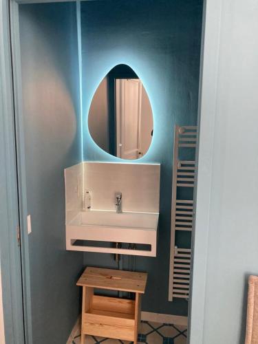 une salle de bain avec un lavabo et un miroir dans l'établissement Chantemerle à partir de 2 personnes, à Villers-sur-Mer