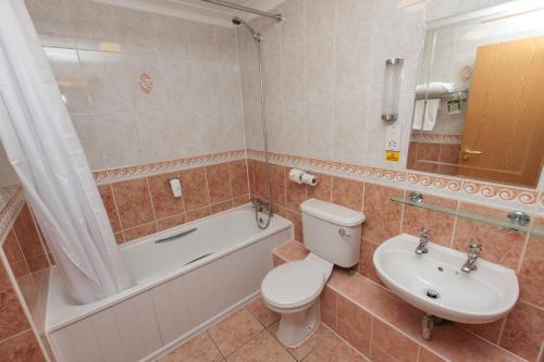 y baño con aseo, bañera y lavamanos. en Boundary, Alfreton by Marston's Inns, en Alfreton