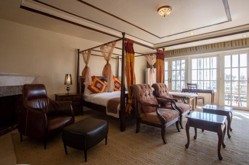 a bedroom with a canopy bed and chairs and a table at Meraki Holistic Wellness Retreat in Burhānilkantha