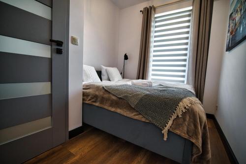 een slaapkamer met een bed en een raam bij LOFT 24 by Housine in Zator