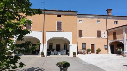 a large building with a courtyard with chairs in it at Piccola Corte Antica in Corticelle Pieve