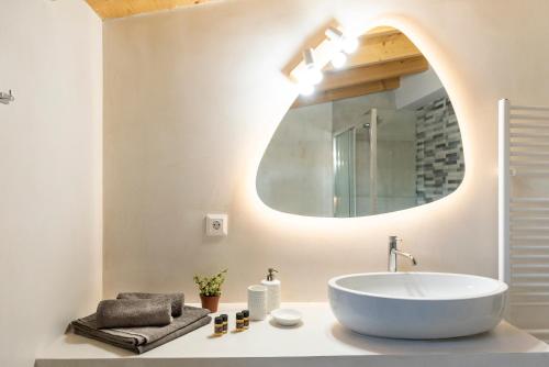 een badkamer met een witte wastafel en een spiegel bij Mariloo’s Apartment in Nafplio