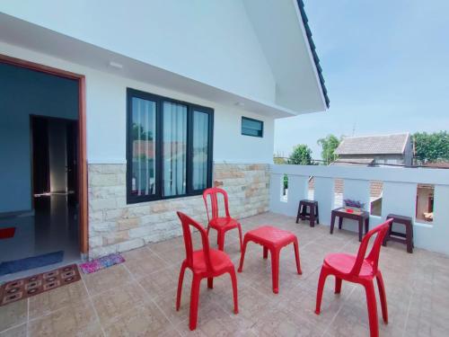 a group of red chairs sitting on a patio at Huize Silitonga in Malang