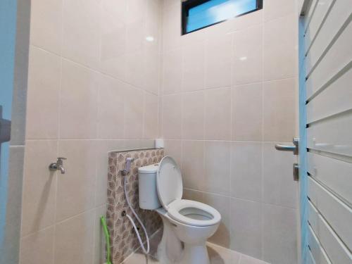 a bathroom with a toilet and a window at Huize Silitonga in Malang