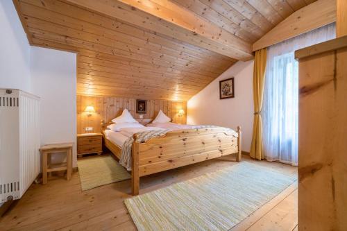 - une chambre avec un lit et un plafond en bois dans l'établissement Apartment Waldesruh, à Rio di Pusteria