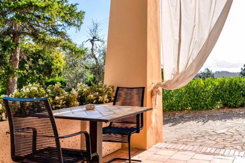 einen Tisch und Stühle auf einer Terrasse in der Unterkunft Podere Bellavista in San Gimignano