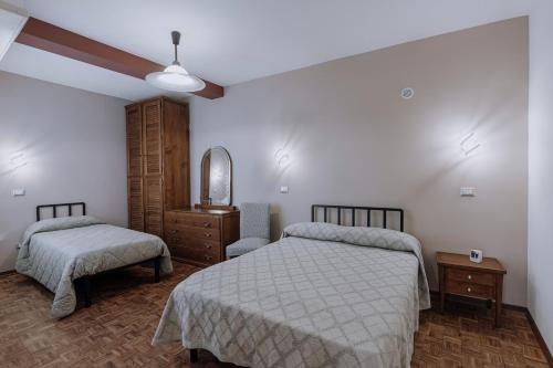 um quarto com 2 camas, uma cómoda e um espelho em Appartamento Maran em Peveragno