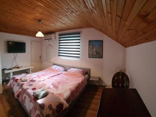 a bedroom with a bed and a wooden ceiling at Hostel FM in Mostar