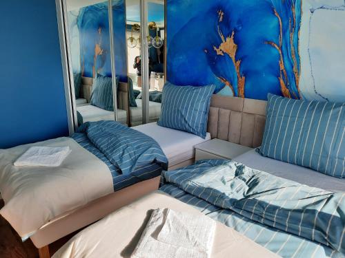 a bedroom with three beds and a mirror at Nadmorski Bursztyn in Rowy