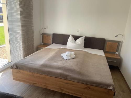 a bedroom with a large bed with two towels on it at Die 1A Pension in Welsau