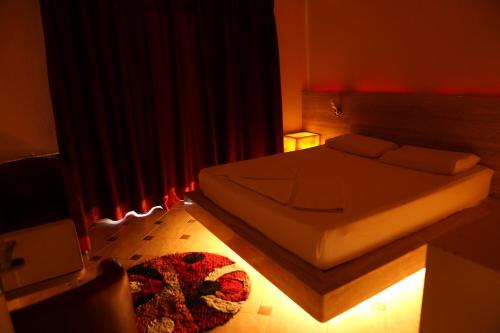 a bedroom with a bed in a red room at Hotel Autostrada (Highway) in Kashari