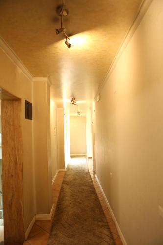 an empty hallway with a ceiling fan and a door at Hotel Autostrada (Highway) in Kashari