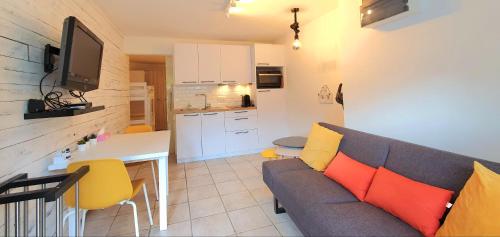 een woonkamer met een bank en een keuken bij Le Petit Nord in De Panne