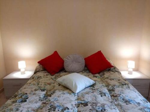 1 dormitorio con 1 cama con almohadas rojas y blancas en La Casa di Tagliacozzo delizioso appartamento centrale con 2 camere e camino en Tagliacozzo