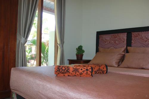 a bedroom with a large bed with a large window at Herry Homestay Kuta Lombok in Kuta Lombok