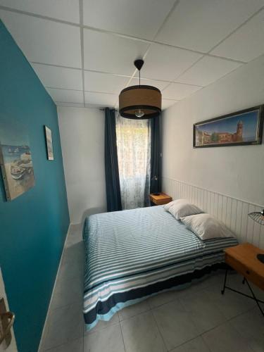 une chambre avec un lit et un mur bleu dans l'établissement Appartement en face de la plage avec barbecue, à Plage dʼArgelès