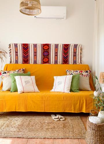 a yellow couch with pillows on it in a living room at Casa Verde Houses in Kos