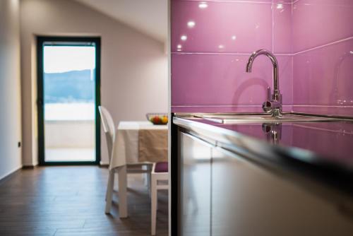 a kitchen with a sink and a dining room with a table at Apartments Ponta Krasici in Tivat