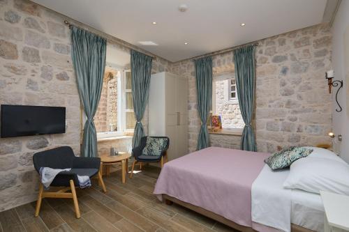een slaapkamer met een bed en een stenen muur bij Studio Nikol in Dubrovnik