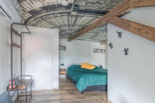 多克姆的住宿－Boutiquehotel Dokkum，一间卧室设有绿色的床和木制天花板