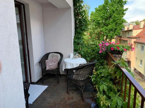 un balcone con tavolo, sedie e fiori di Apartamenty Tęcza a Świnoujście