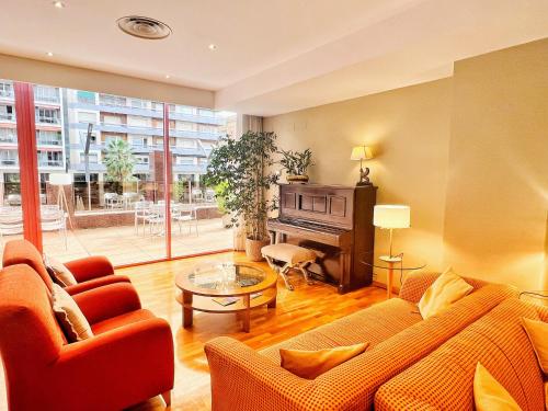 a living room with a couch and a piano at Mercure Carlton Rioja in Logroño