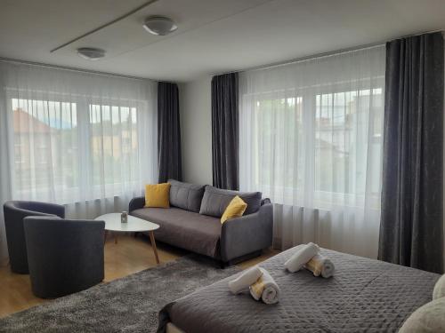 a living room with a couch and a couch and window at Apartman centrum v súkromí in Martin