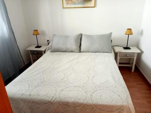 a bedroom with a bed with two nightstands and two lamps at Casa rural El Limonero in Campano