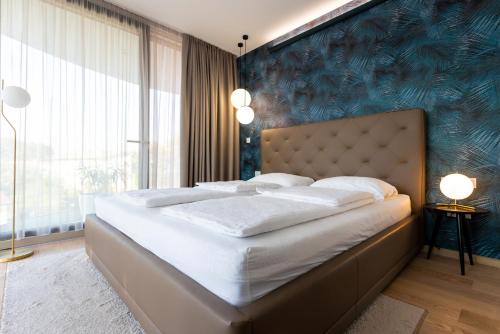 a bedroom with a large bed with a blue wall at Villa Piano Residences in Vantačići