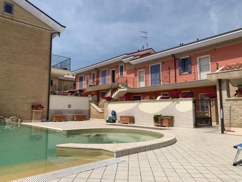 a courtyard with a swimming pool in front of a building at il borghetto Bennie en Liisa in Cupra Marittima