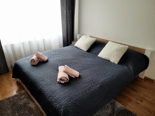 a bed with two pink towels on top of it at Apartman centrum v súkromí Reštaurácia U Jakuba in Martin