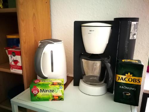 a coffee maker and a box on a table at Quiet City-Apt, 4min City-Center, 18min Fair Nürnberg!!! in Nürnberg