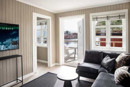 a living room with a couch and a window at Solsiden Brygge Rorbuer in Ballstad