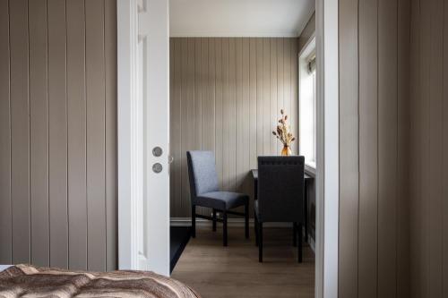 a bedroom with a desk and two chairs and a table at Solsiden Brygge Rorbuer in Ballstad