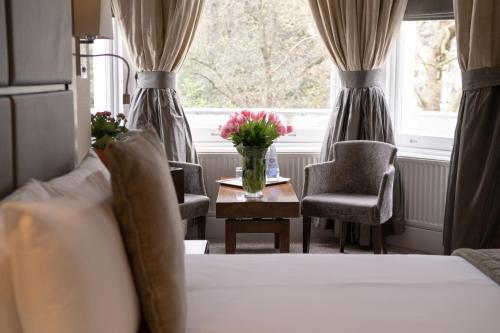 a bedroom with a bed and a table with flowers on it at Strathmore Hotel in London