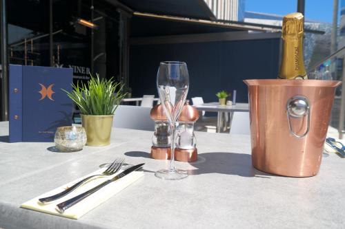 a table with a wine glass and a bottle on it at Novotel Leicester in Leicester