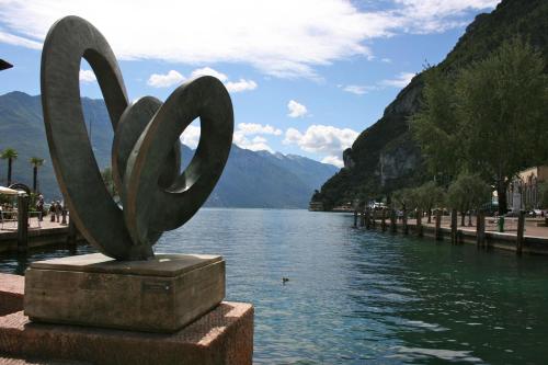 a statue sitting on the side of a body of water at Alle Porte in Riva del Garda