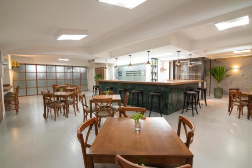ein Restaurant mit Holztischen und -stühlen und einer Bar in der Unterkunft EKO HOTEL in Presidente Prudente