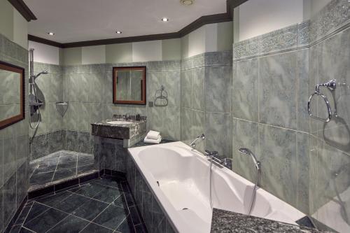 a large bathroom with a tub and a shower at Van der Valk Hotel Arnhem in Arnhem