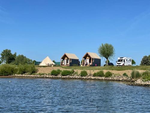 a group of houses on the shore of a river at Bell Tent in Heerewaarden