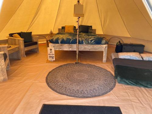 a tent with a rug in the middle of a room at Bell Tent in Heerewaarden