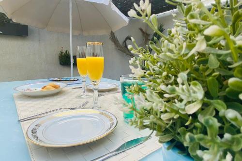 stół z talerzami i szklankę soku pomarańczowego w obiekcie La Perle Marine 3 w mieście Le Grau-du-Roi