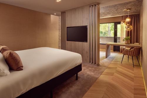 a hotel room with a bed and a desk and a television at Van der Valk Hotel Arnhem in Arnhem