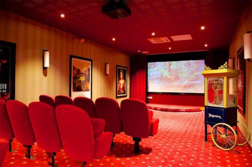a conference room with red chairs and a projection screen at Résidence Service Seniors MONTANA in Avignon