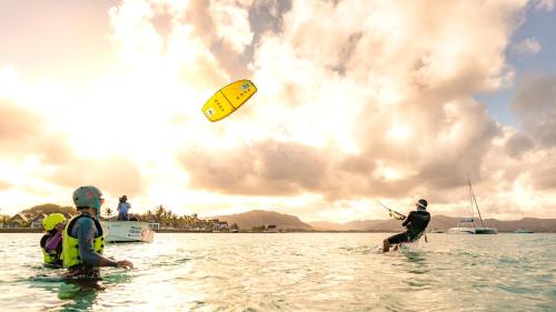 a group of people in the water with a kite at Preskil Island Resort in Blue Bay