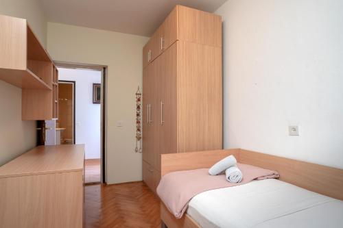 a bedroom with a bed and a large wooden cabinet at Spacious Green Home in Hvar