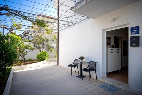 a patio with two chairs and a table in a building at Spacious Green Home in Hvar