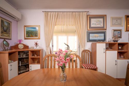 a kitchen with a table with a vase of flowers on it at Spacious Green Home in Hvar